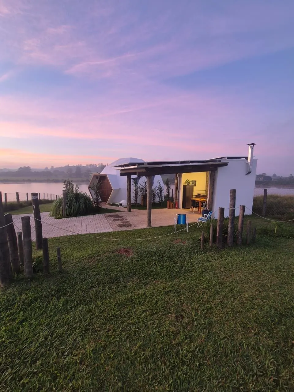 O domo ao amanhecer, com o céu lilás sobre a represa