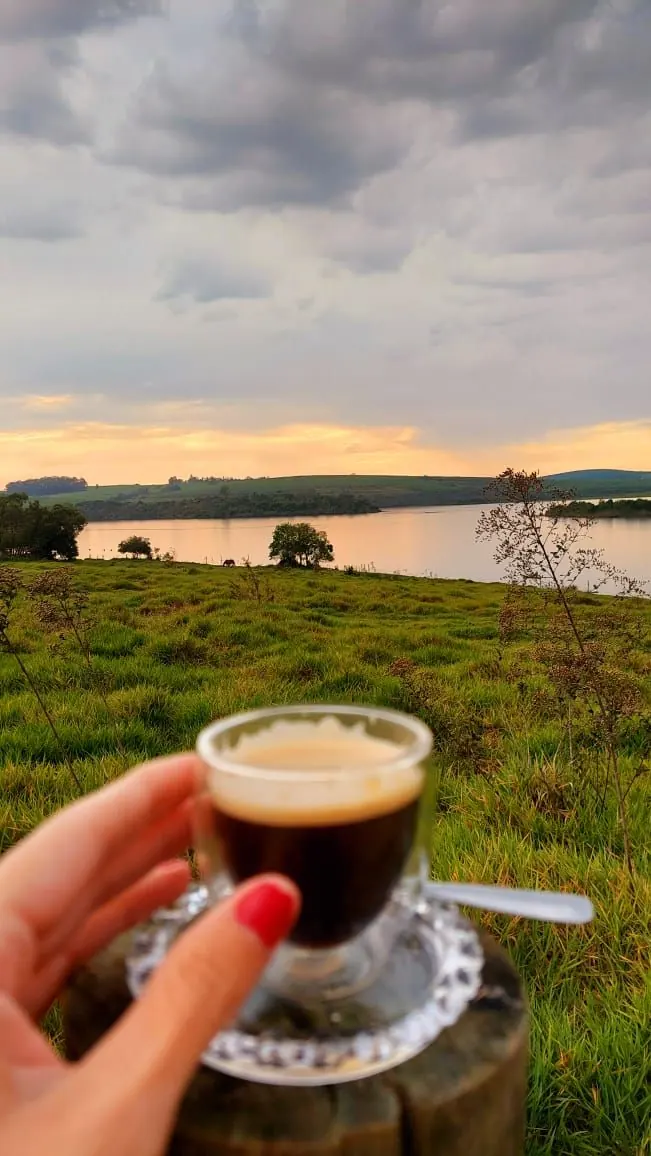 Uma xícara de café diante da represa