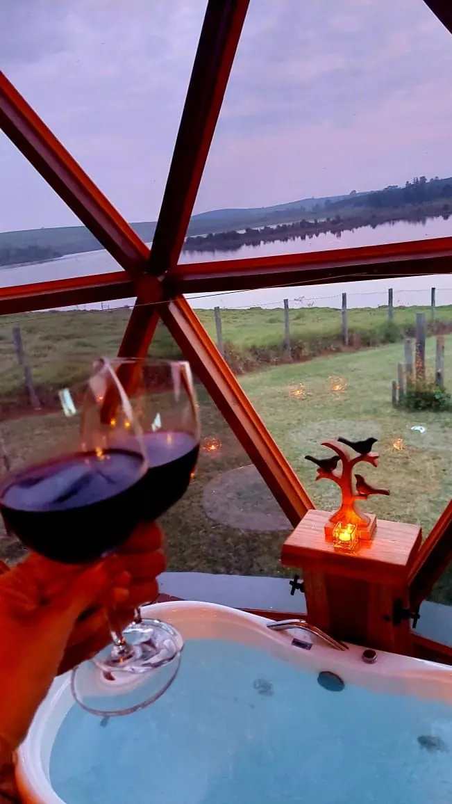 O ofurô junto à janela triangular, com uma taça de vinho