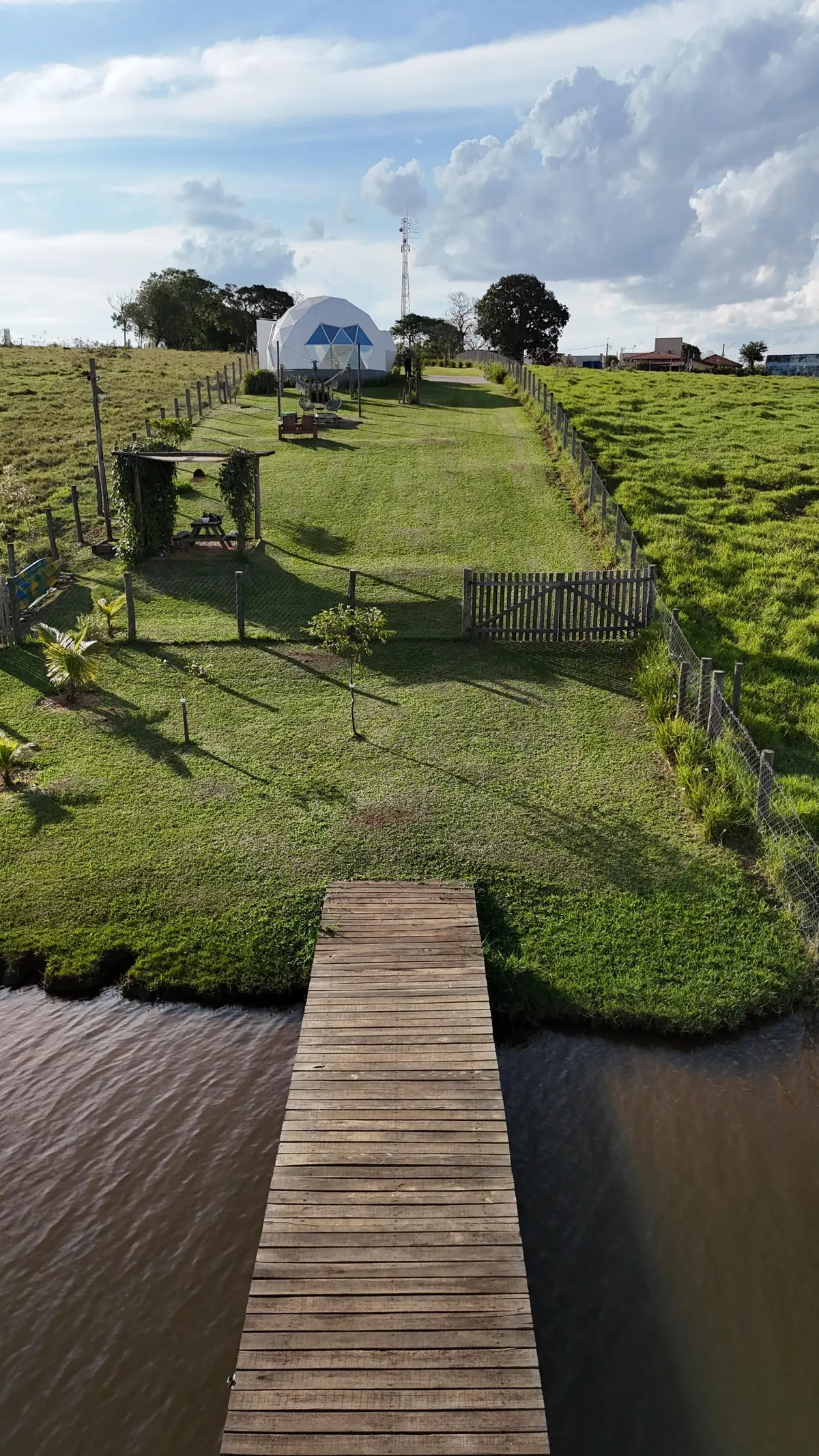 O píer sobre a represa, com o domo lá no fim do gramado