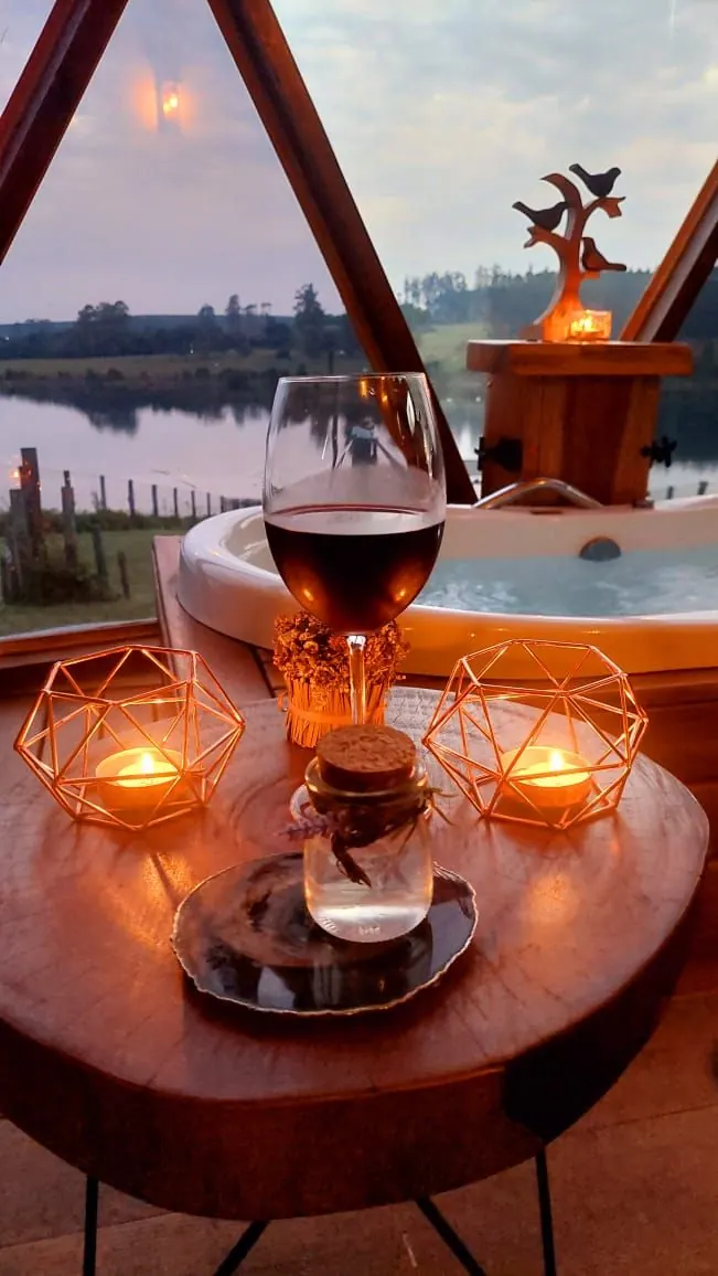Uma taça de vinho e velas ao lado do ofurô